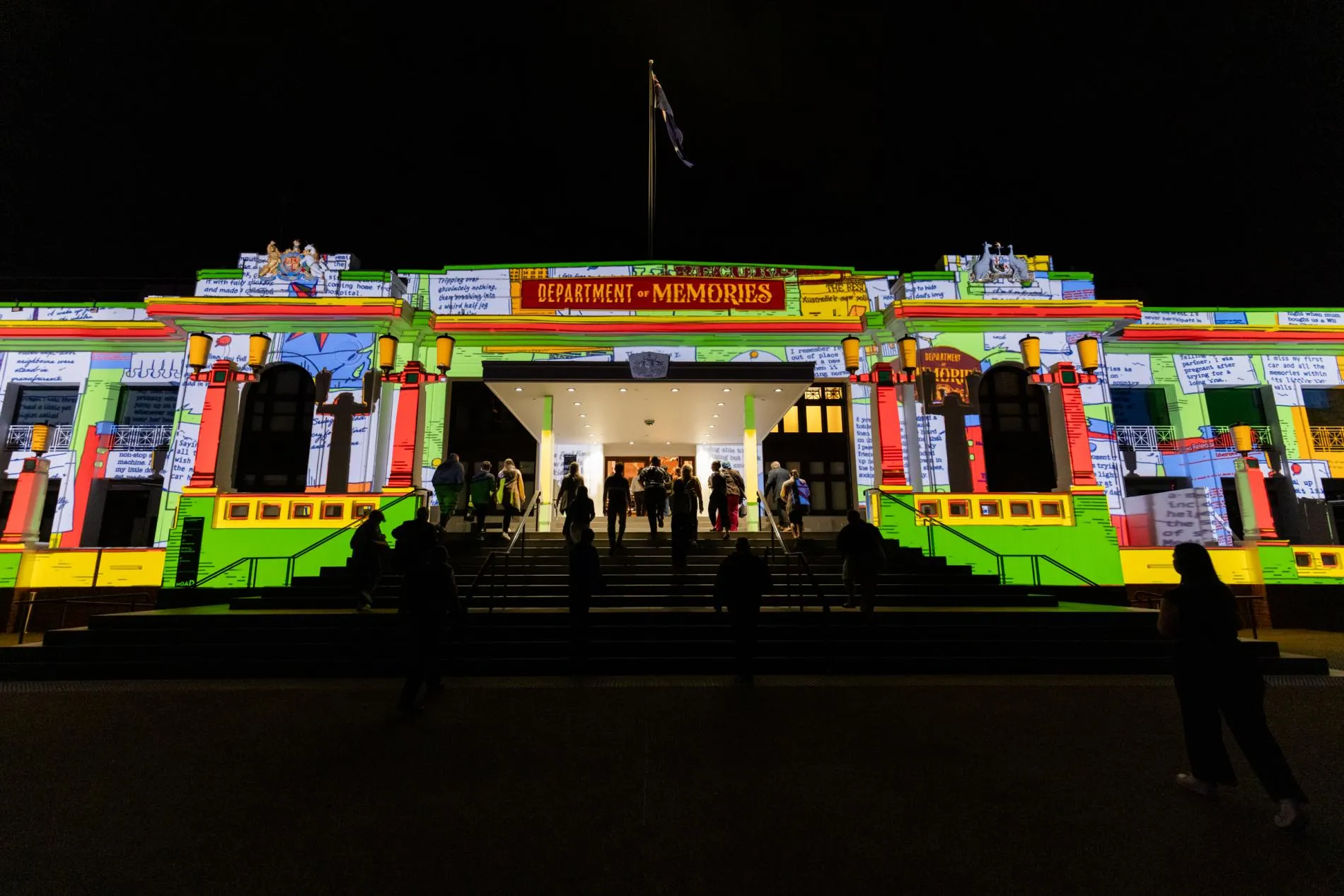 The front of Old Parliament House lit up for Enlighten 2026, above the entryway there is a graphic that says 'Department of Memories'.