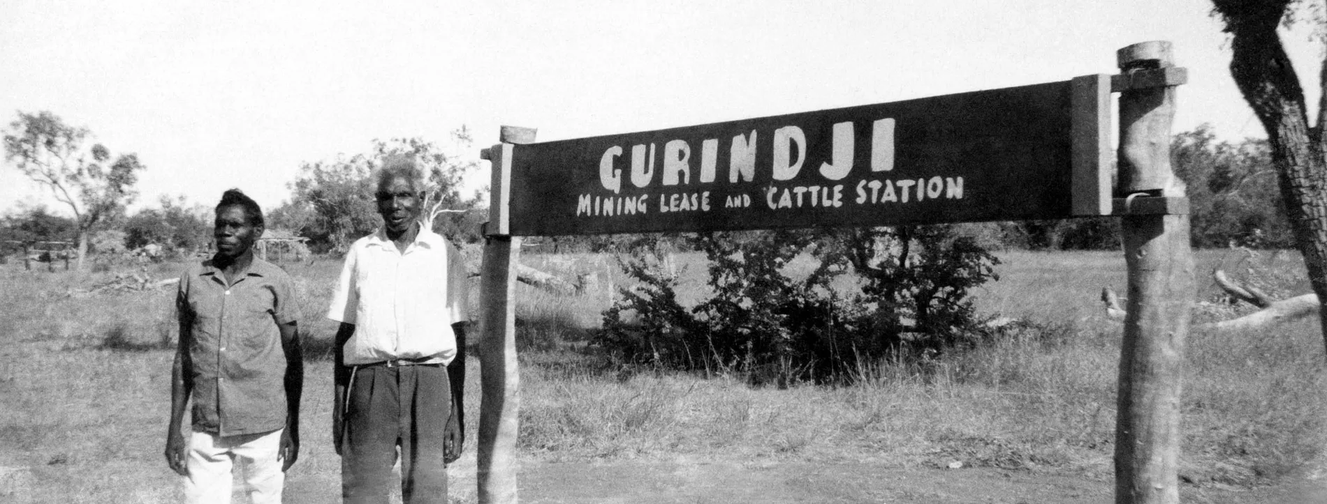 Vincent Lingiara and Mick Rangiari stand next to the Gurindji Mining Lease and Cattle Station sign.