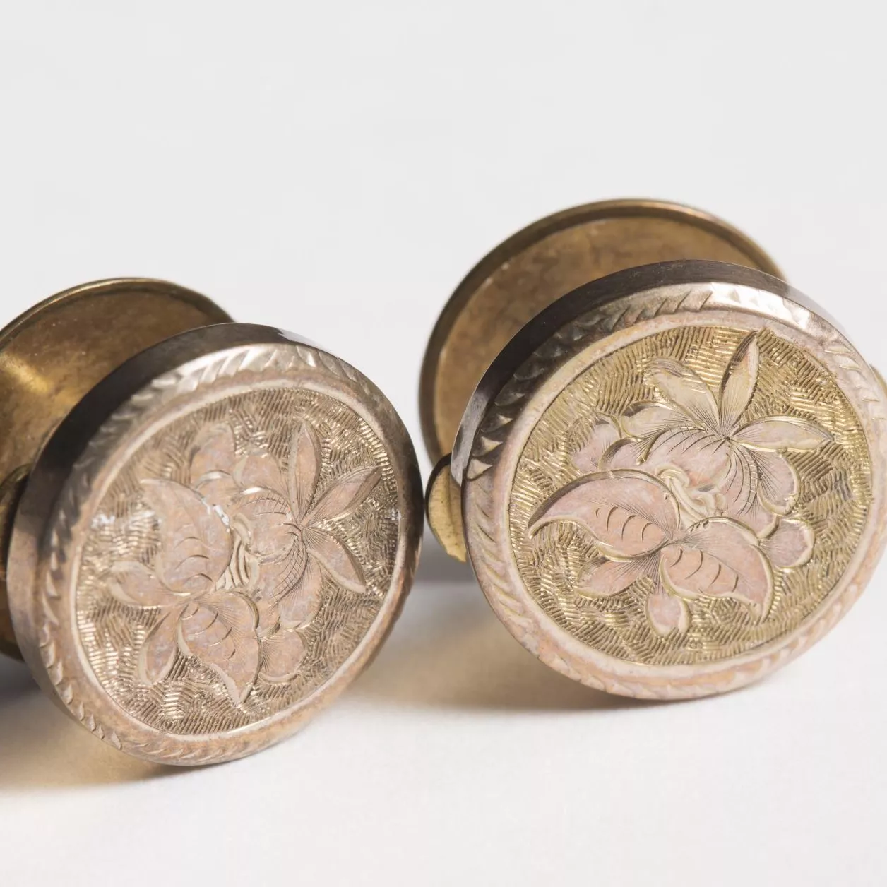 Photograph of two brass coloured cufflinks