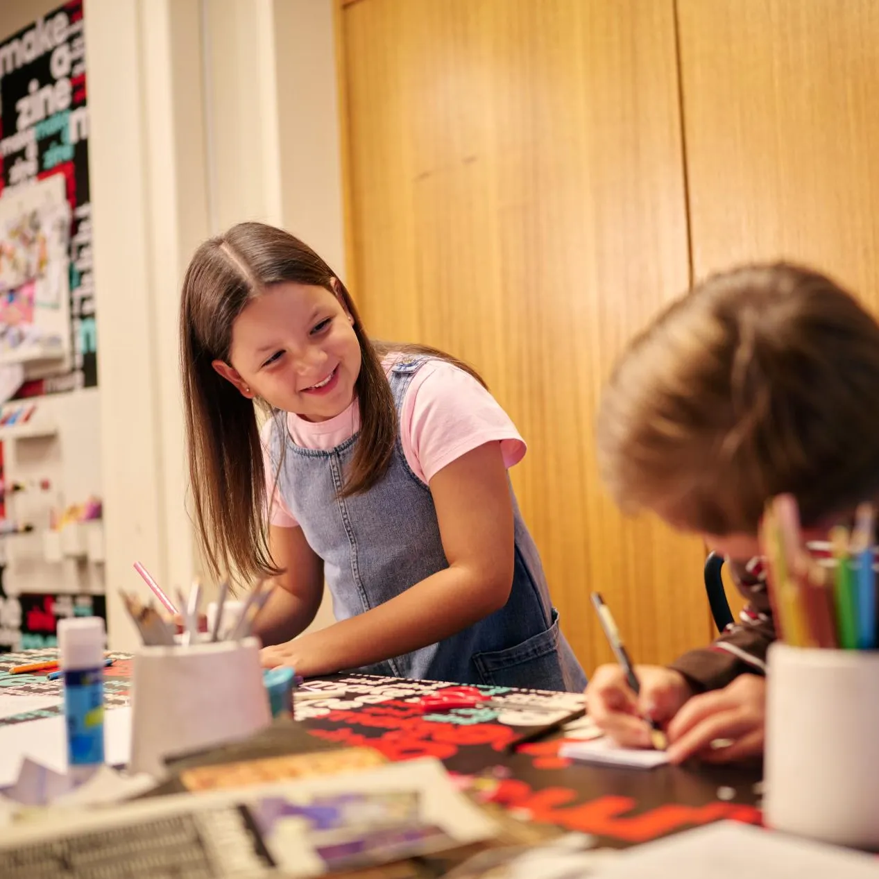 Two children creating their own zines in the Zine Lounge at the Museum of Australian Democracy at Old Parliament House.