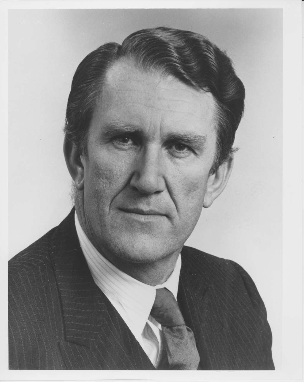 A man, Malcolm Fraser, wearing a pinstripe suit.