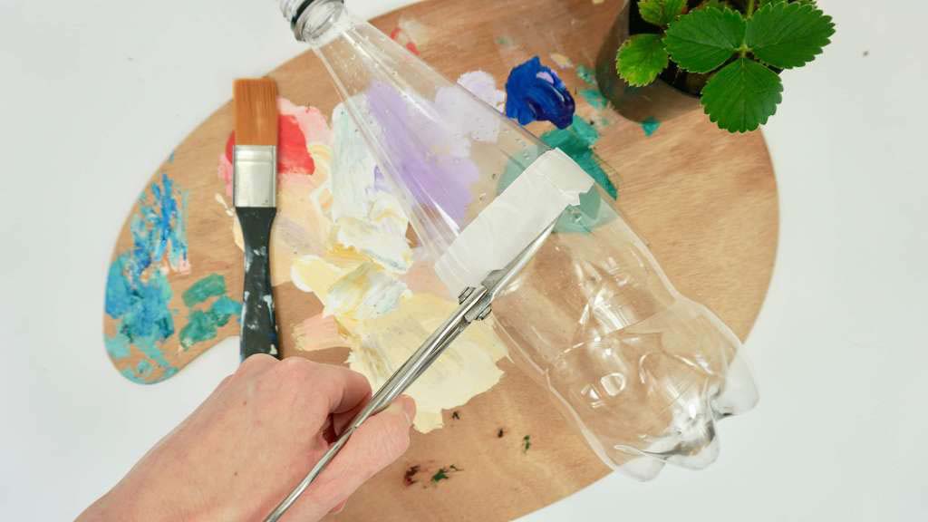 A paint palette, a plastic bottle, paint brushes and a little herb pot. 