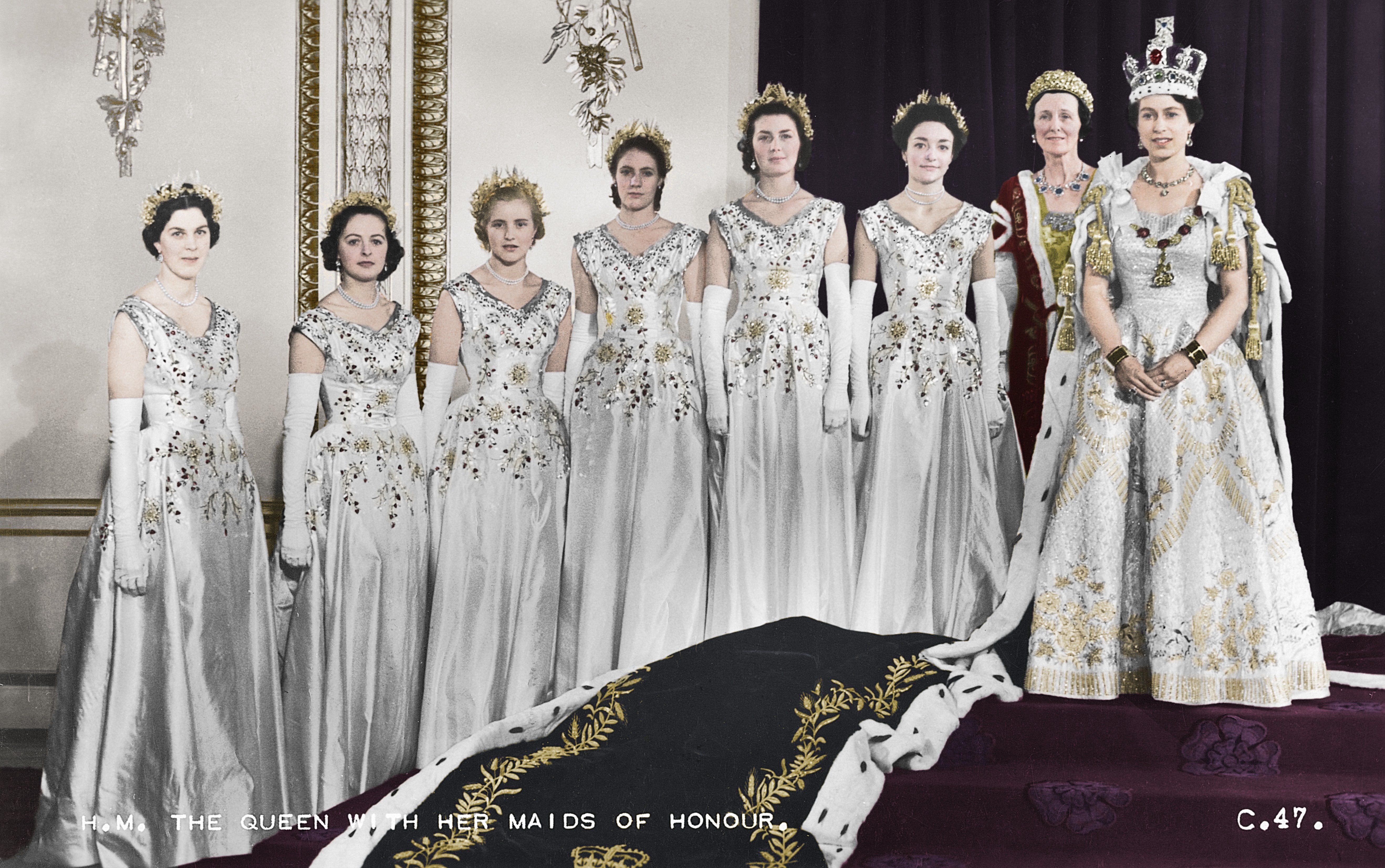 A colourised photograph of Queen Elizabeth, wearing her coronation gown, accompanied by seven maids of honour.