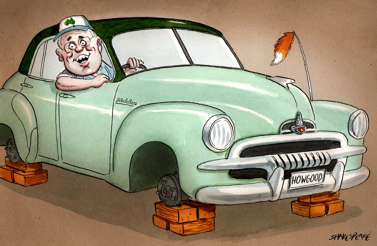 Scott Morrison sits in an FJ Holden. It does not have wheels, and is up on bricks. Number plate is 'How good'.