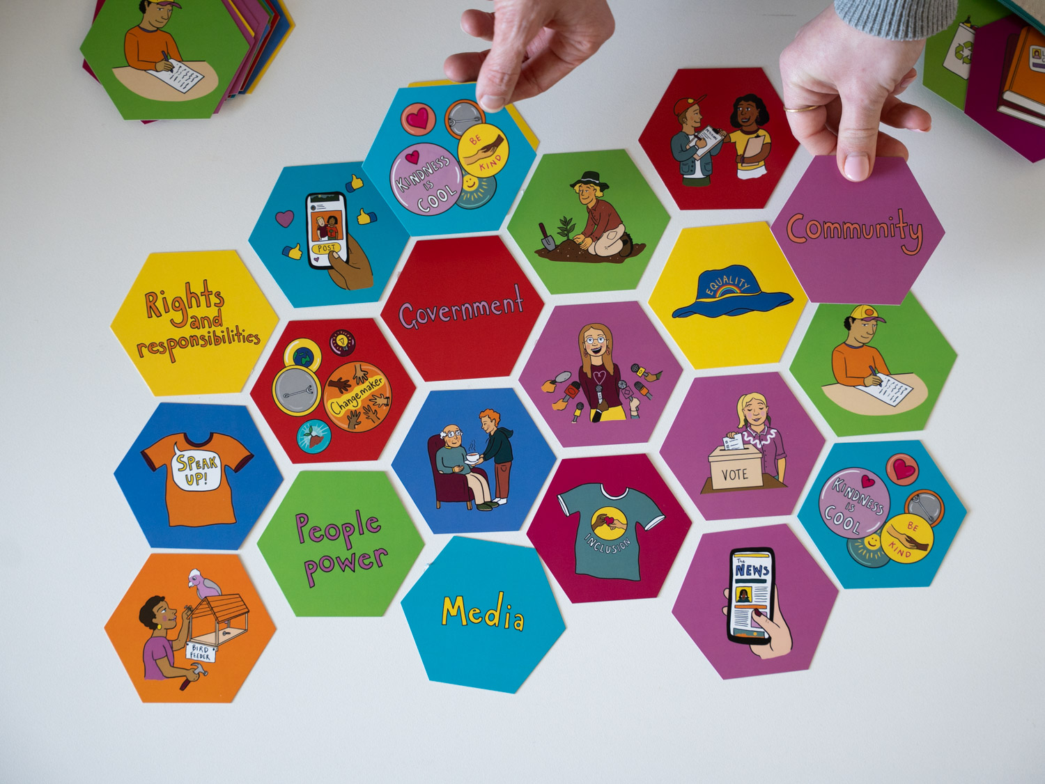 Hexagonal coloured tiles featuring words about civics and democracy.