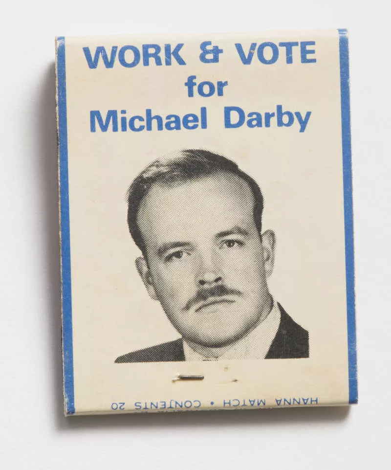 Photograph of a matchbook with a mans face on it.