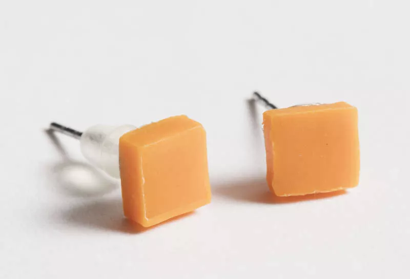 Photograph of two small square orange plastic earrings. 