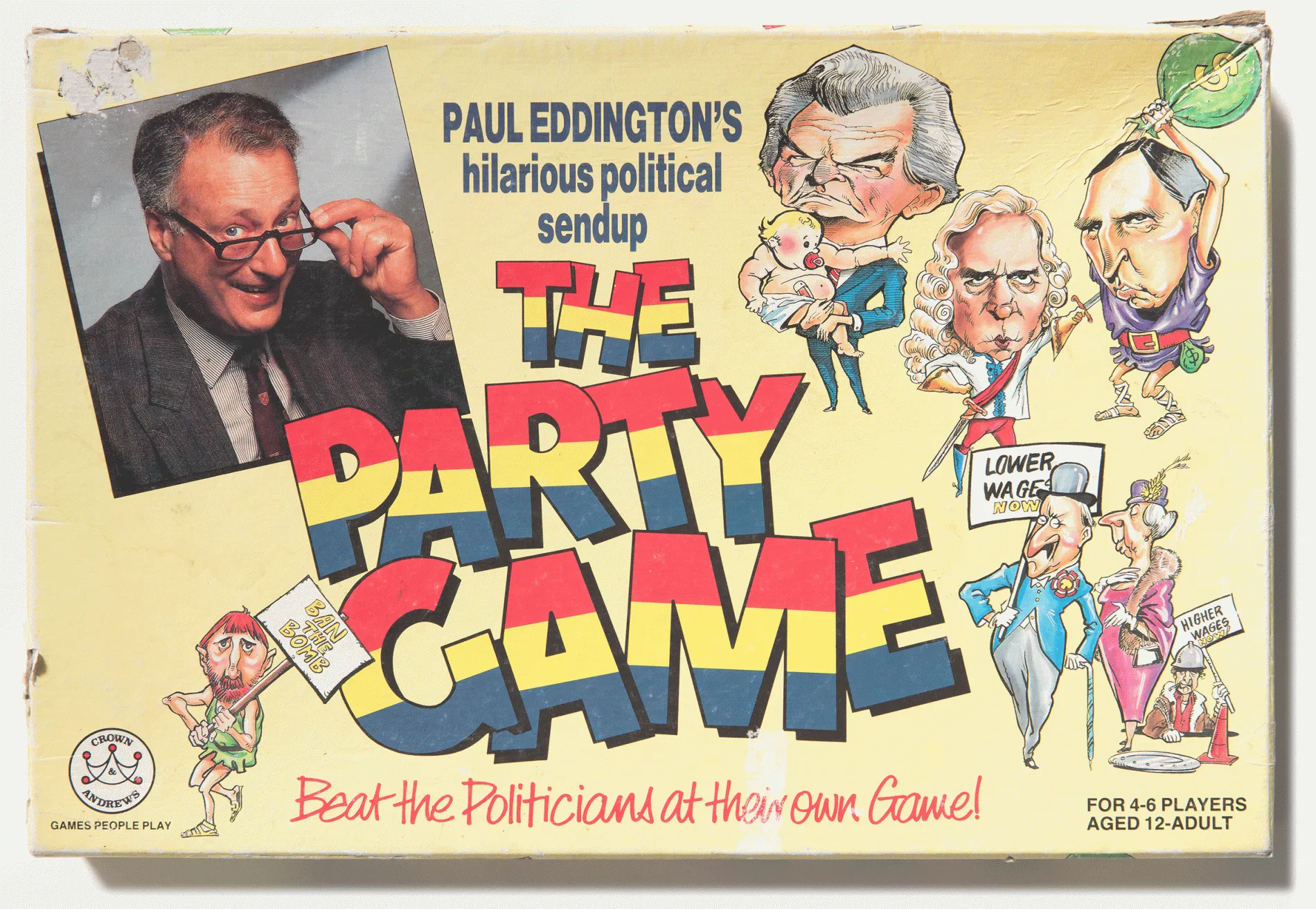 A yellow cardboard board game box that's faded with scuffs around the edges. The words Party Game in bold yellow, red and blue letters is next to a photo of a man in a grey jacket with glasses that he touches while he smiles. Caricatures of politicians feature on the box. 