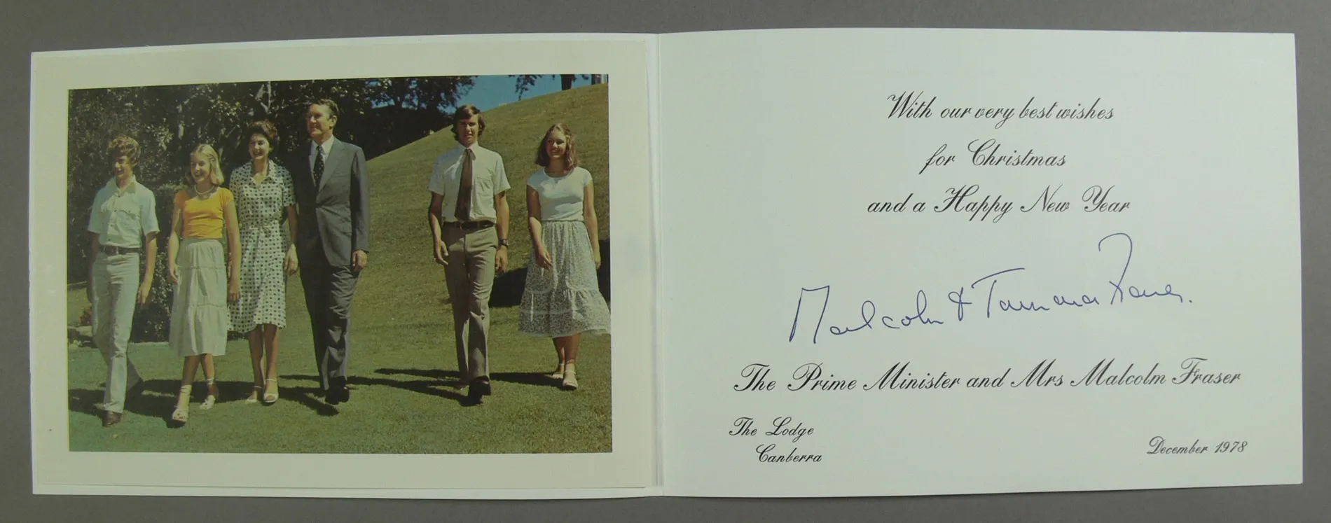 A Christmas card featuring a photo of Malcolm and Tamie walking down a grassy hill with their two sons and two daughters.