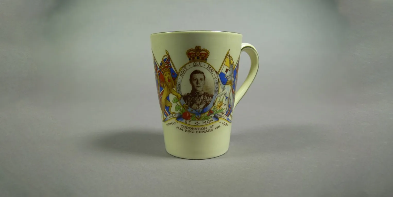 A ceramic mug featuring a portrait of Prince Edward, framed with the British coat of arms, with the words 'Coronation of H.M. King Edward VIII' and '12th May 1937'.