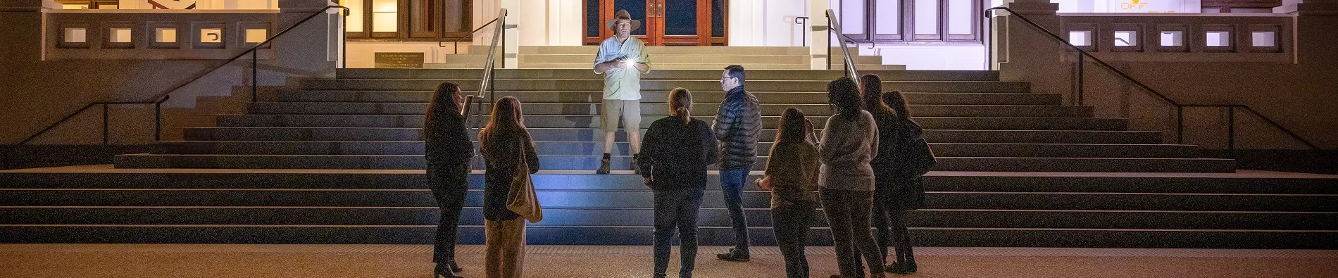 Tim the Yowie Man with a tour group at the front steps of Old Parliament House.