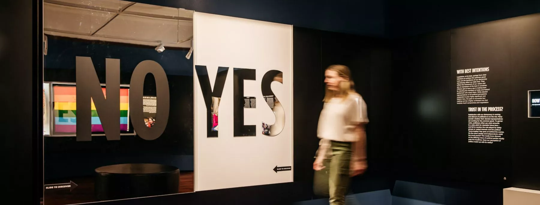 A visitor walking past a large "NO or YES" display