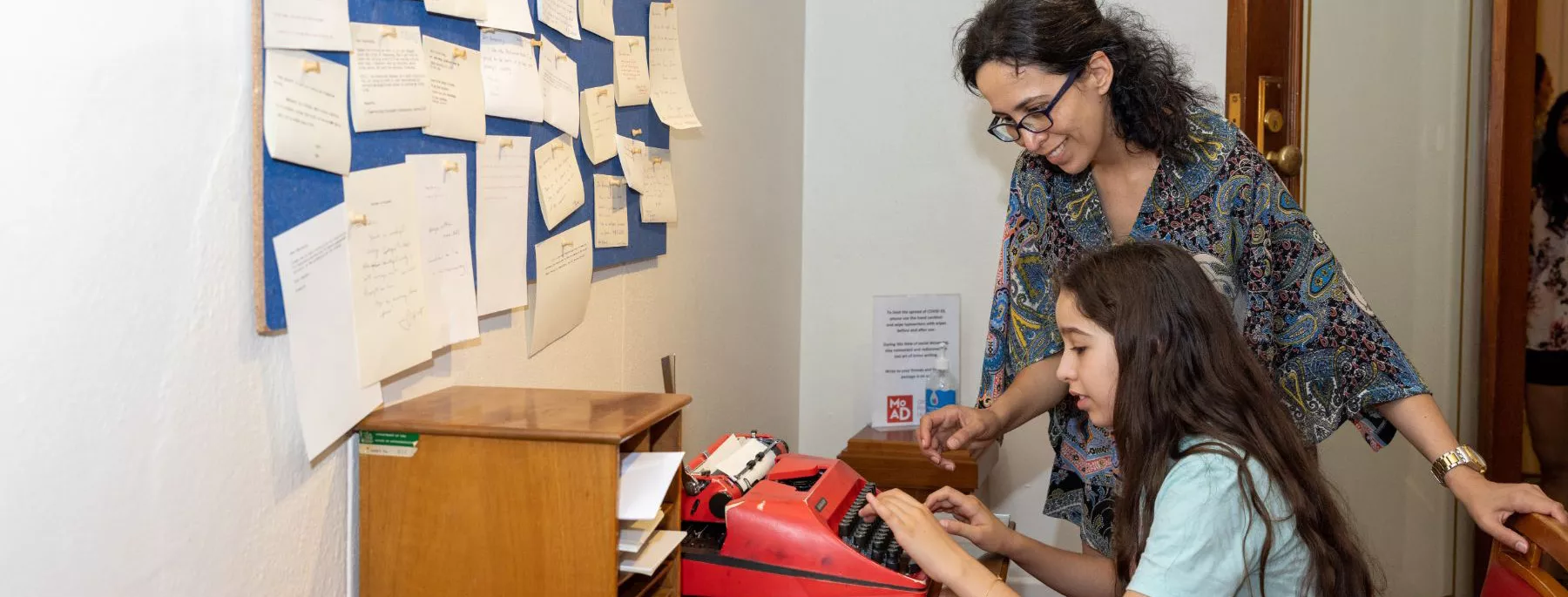 One visitor sat trying out a red typewriter while another watches