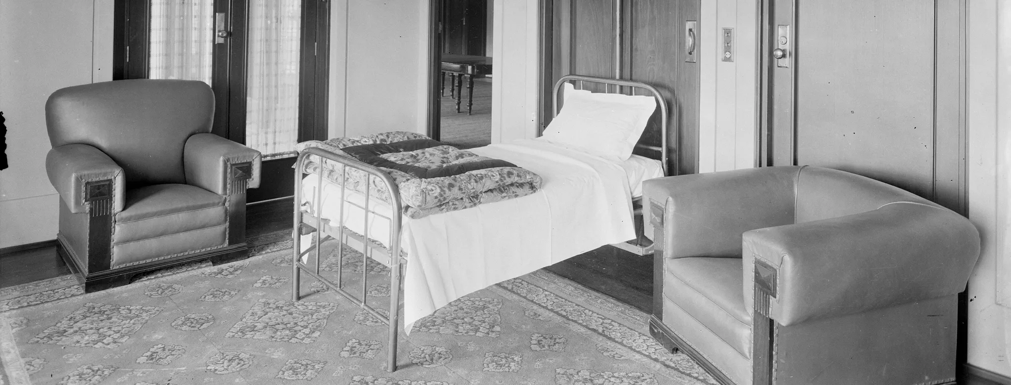 The Speaker's Room, Old Parliament House, with a bed folded out from a cupboard, covered with white sheets, a pillow and a folded floral quilt..