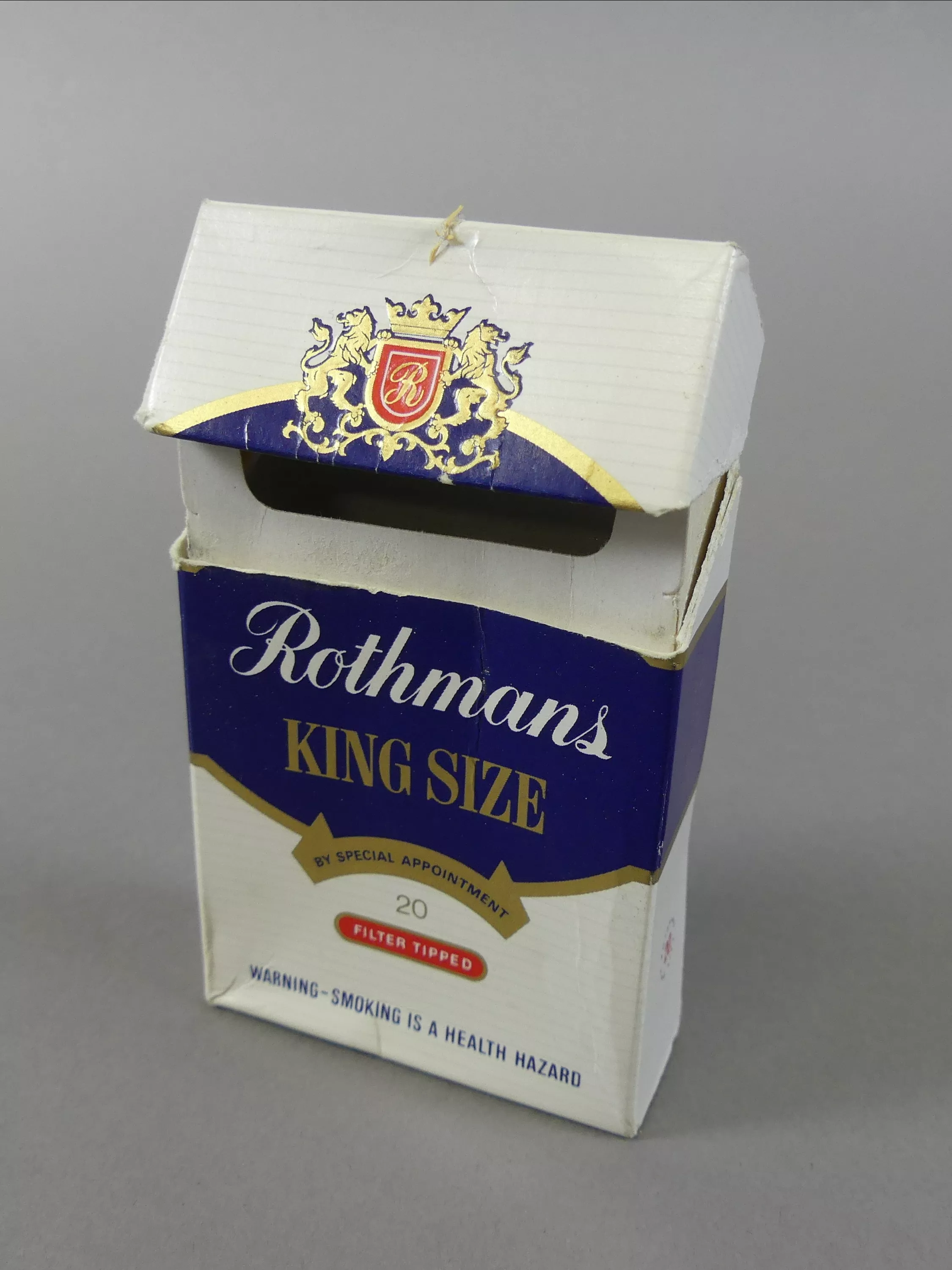 An empty cardboard packet of Rothmans king size cigarettes.