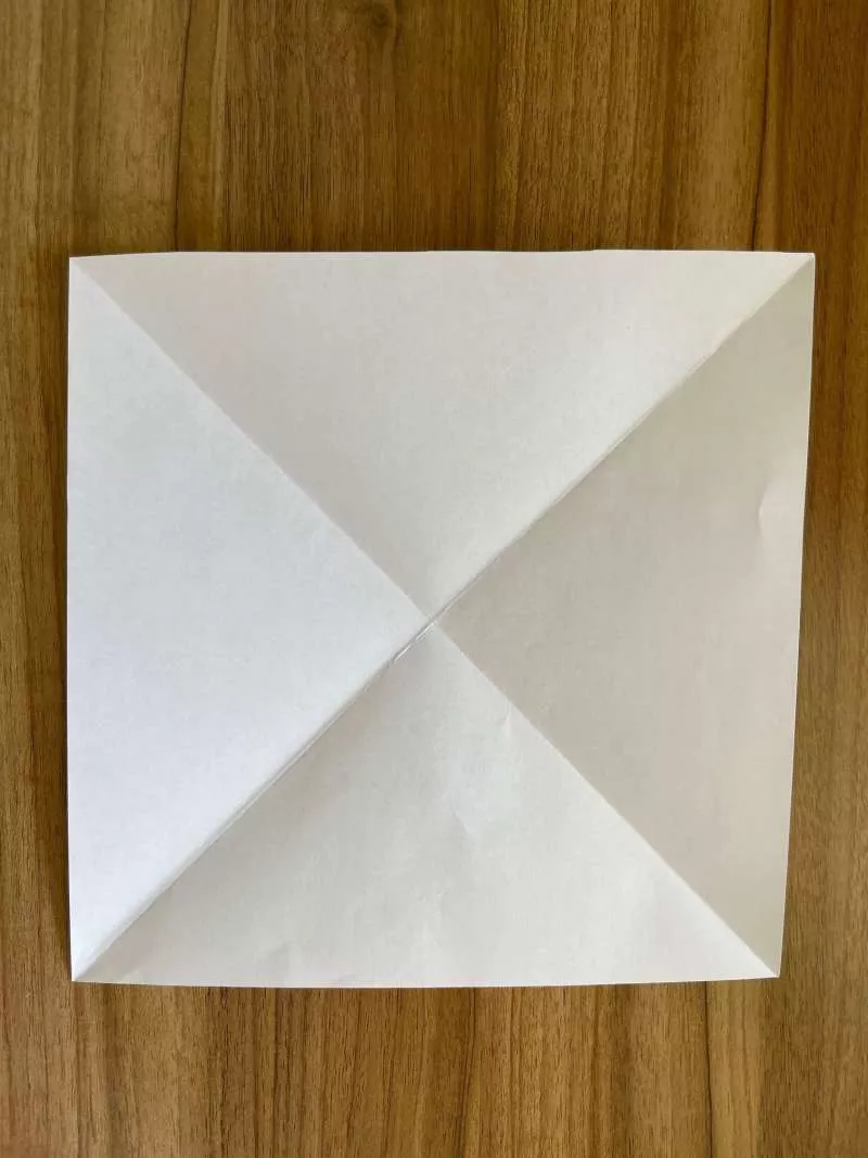 A square piece of paper with diagonal creases. 