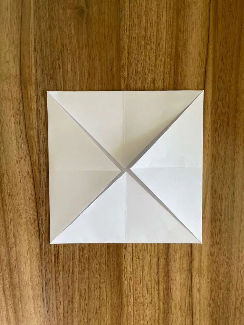 A piece of paper folded into 4 triangles that meet in the middle. 