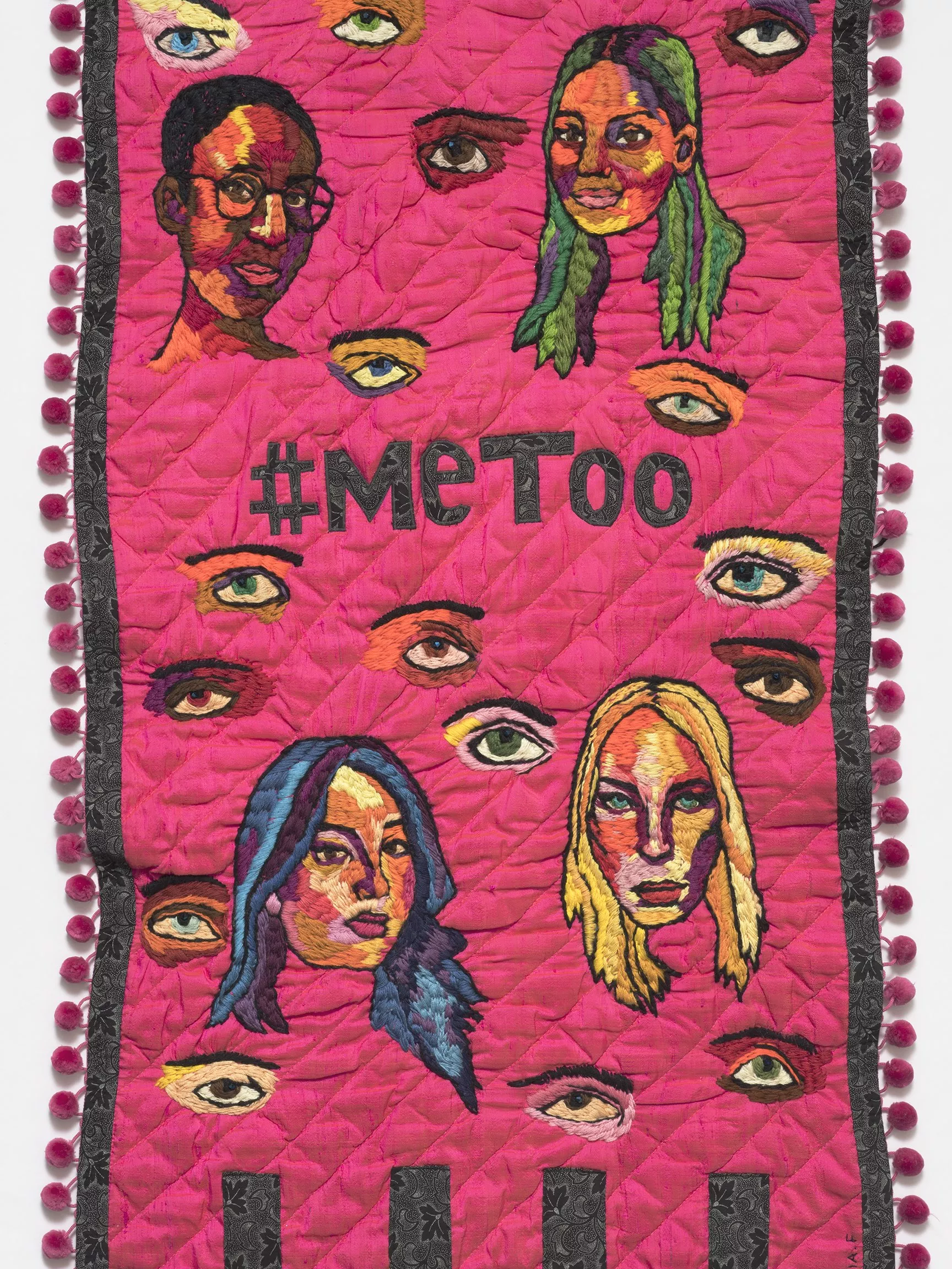 A pink embroidered banner with the words #metoo in the centre and images of women's face surrounding it. 