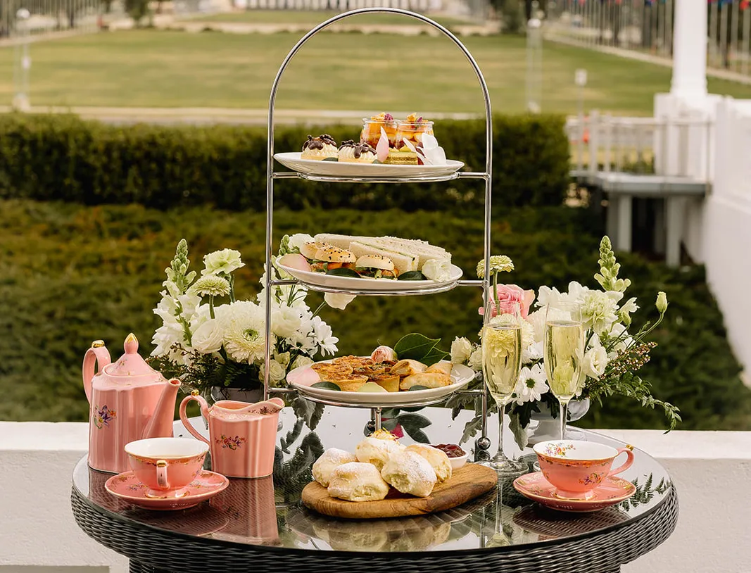 An outdoor table with high tea. 
