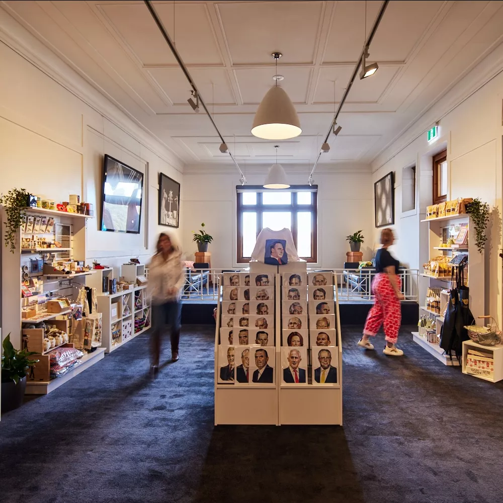 Some visitors shown as a blur walk around the MoAD shop and look at postcards, t-shirts and gifts. 