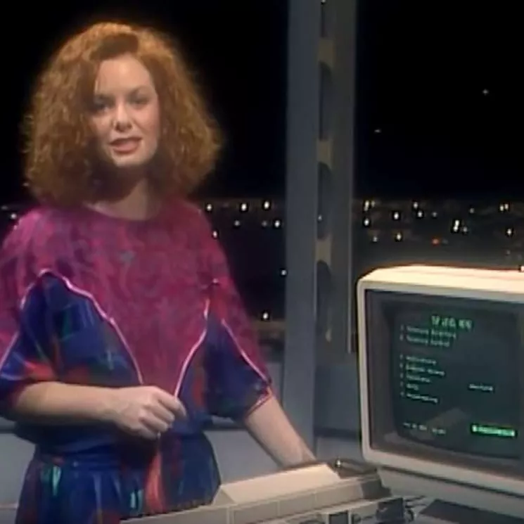 TV presenter Carmel Travers, wearing a blue and purple dress, demonstrating the Computerphone on 'Beyond 2000'.