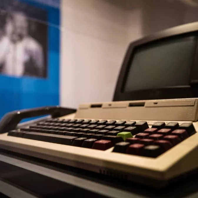 A combined computer, keyboard and telephone handset with a black monitor screen.