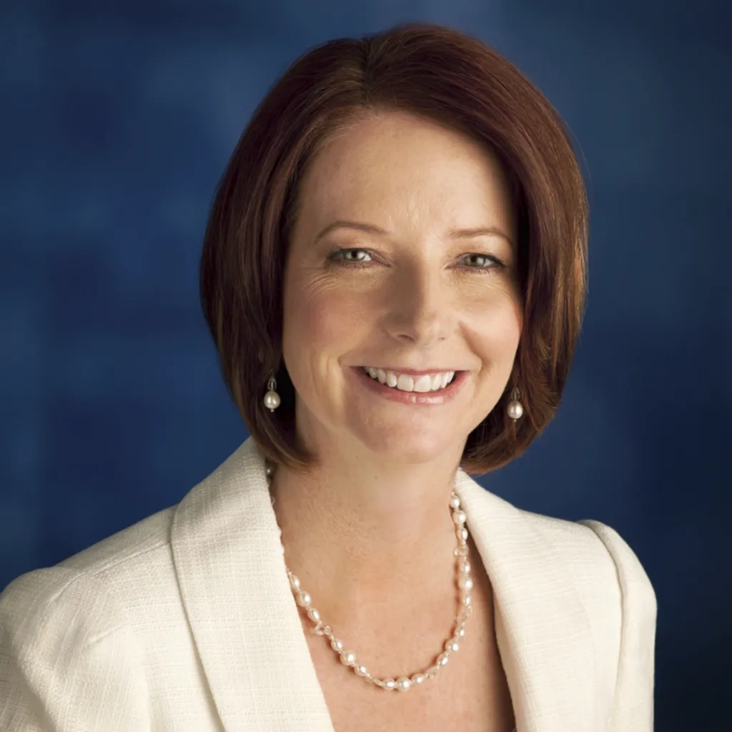 Julia Gillard wearing a pearl necklace and earrings and a white jacket.