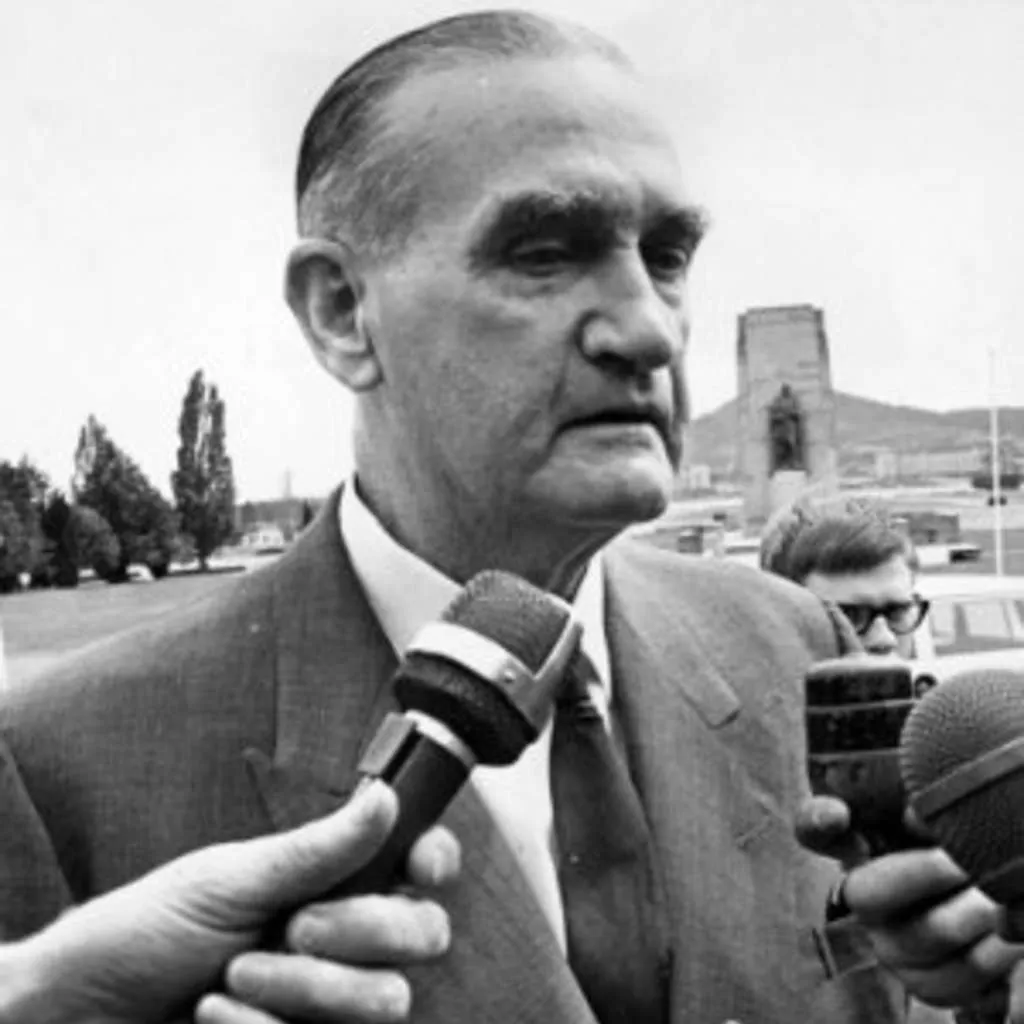 John McEwen speaking into microphones in front of Old Parliament House.