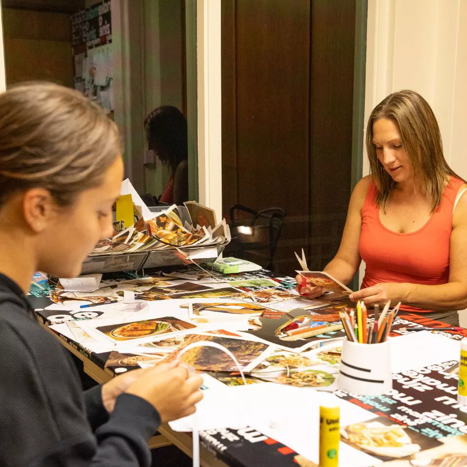 Two visitors having a go at creating their own zine