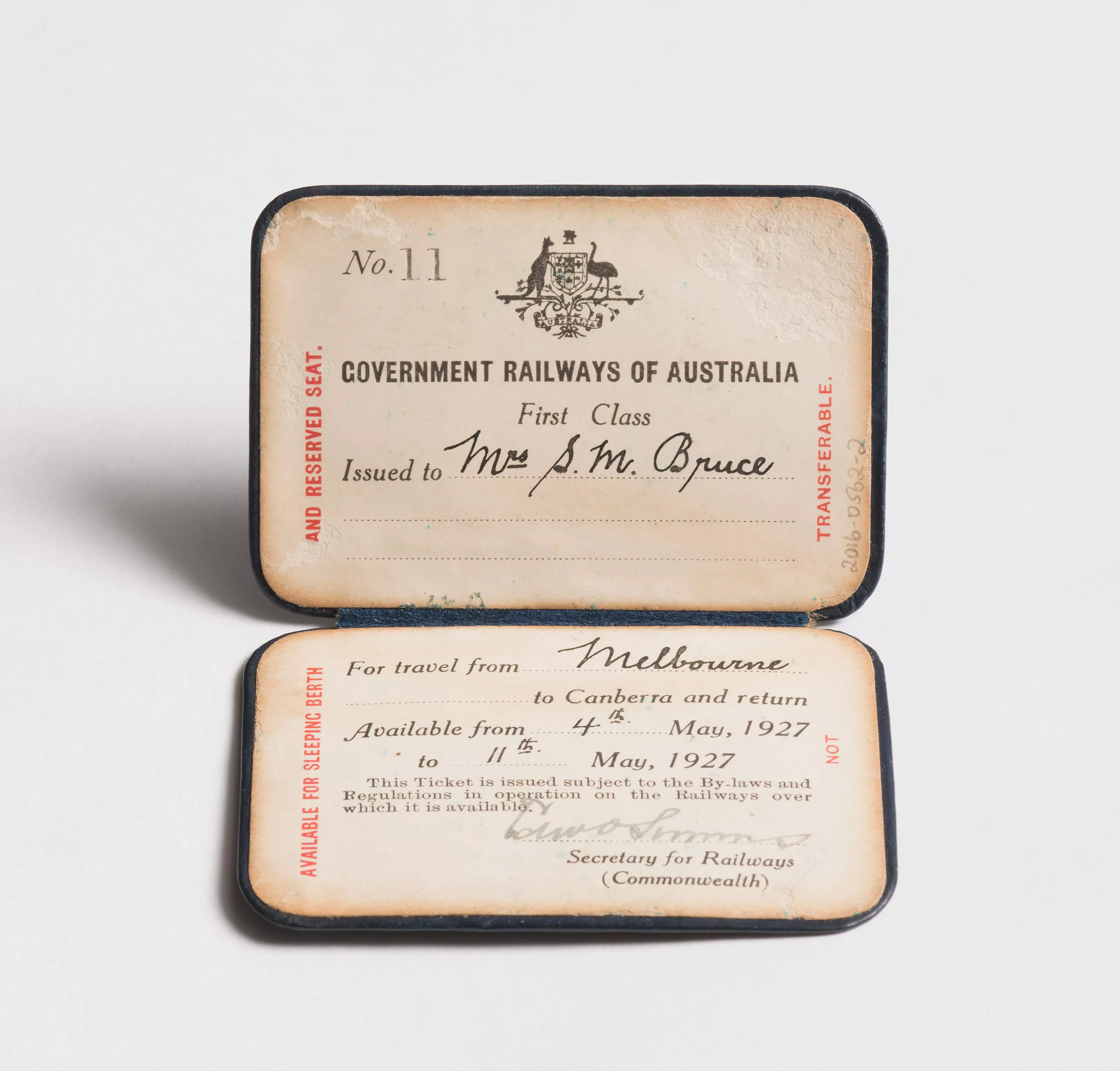 A faded paper railway ticket with cursive handwritten notes saying 'Mrs M Bruce for travel from Melbourne to Canberra'