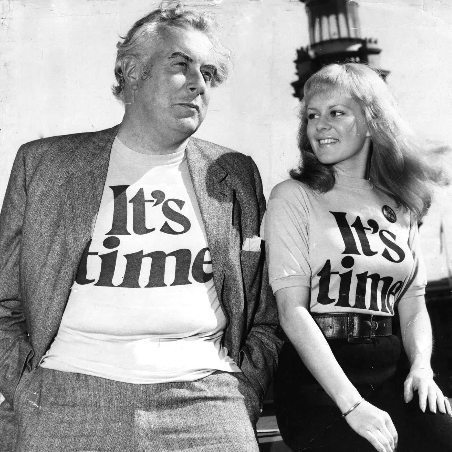 A relaxed Gough Whitlam and a smiling Patricia Amphlett posing together in t-shirts emblazoned with the words ‘It’s time’.