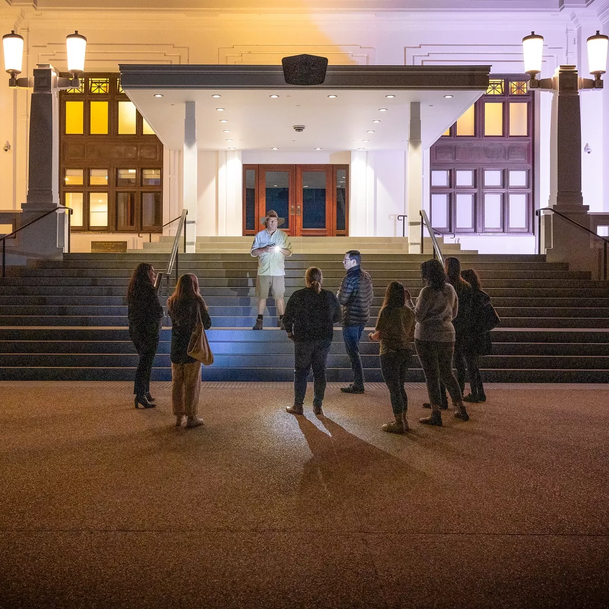 Tim the Yowie Man with a tour group at the front steps of Old Parliament House.