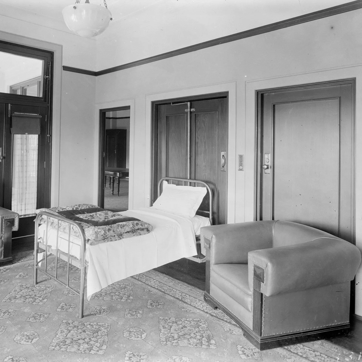 The Speaker's Room, Old Parliament House, with a bed folded out from a cupboard, covered with white sheets, a pillow and a folded floral quilt..