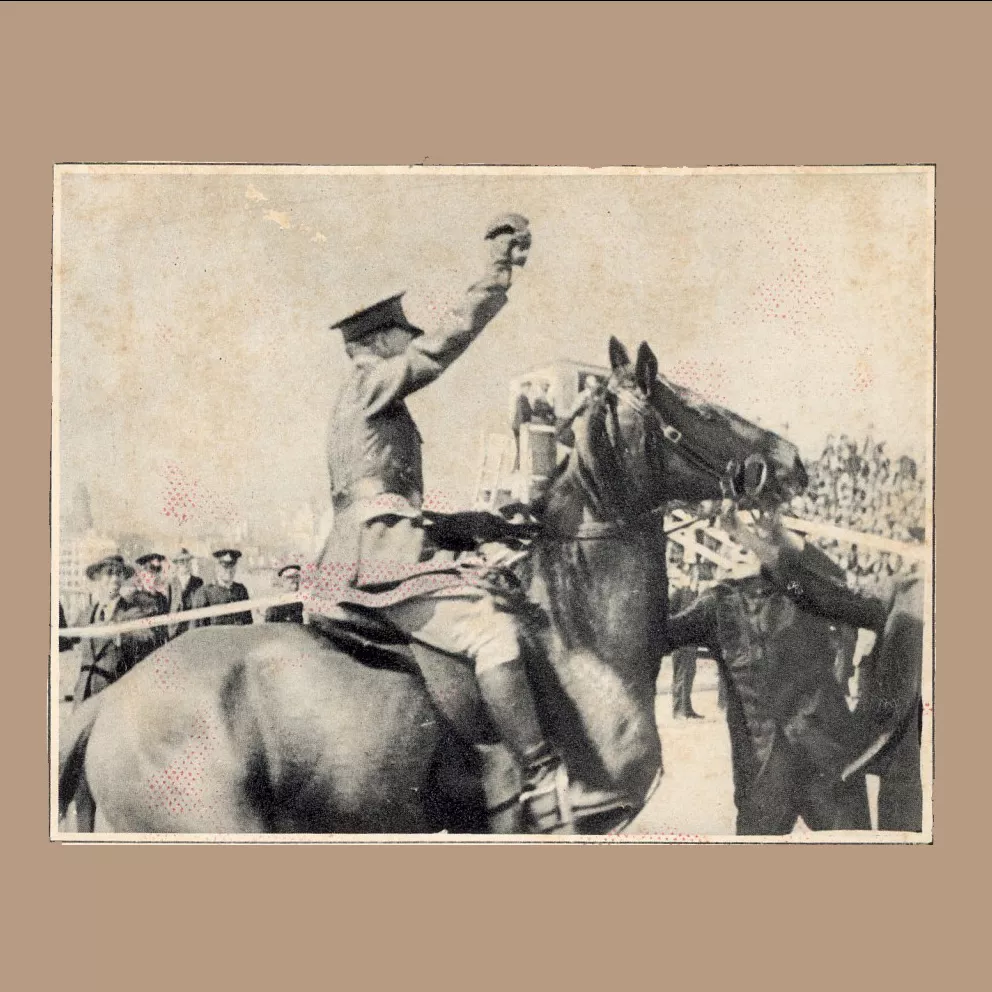 Black and white published photo of Francis de Groot, in uniform, sitting on a horse, sword raised, surrounded by people.