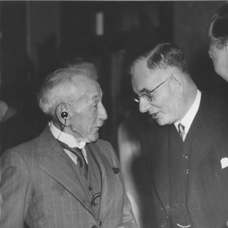 Billy Hughes wearing his 'accousticon', in conversation with John Curtin and the Duke of Gloucester.