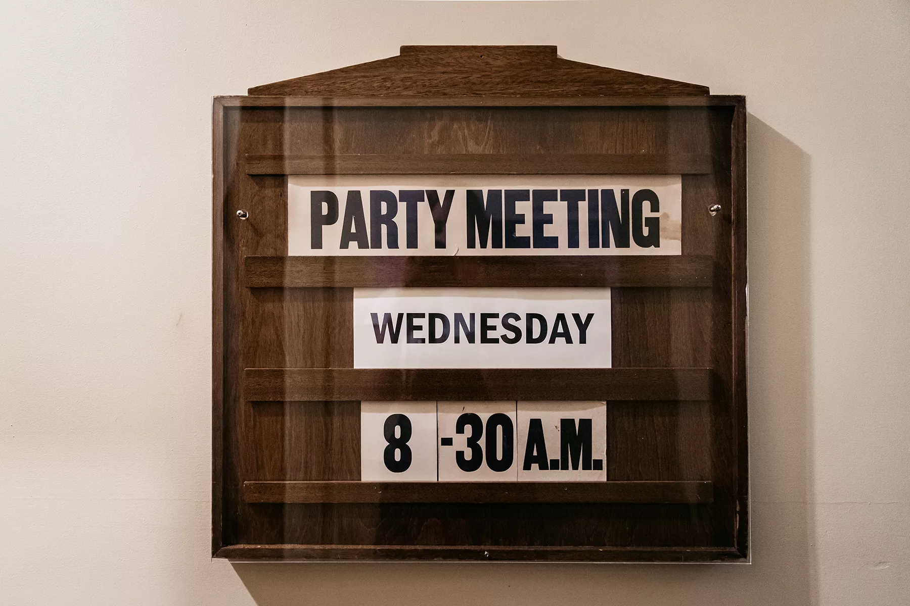 A wooden sign showing the date and time of the next party meeting