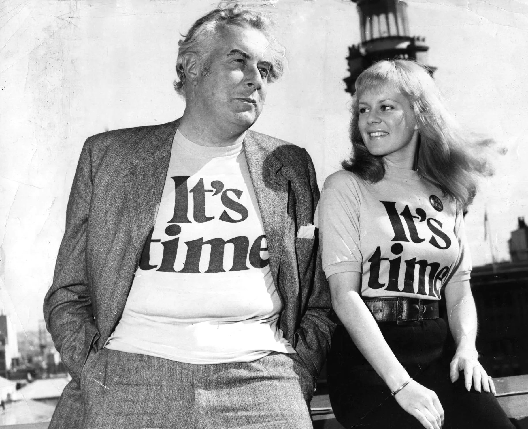 A relaxed Gough Whitlam and a smiling Patricia Amphlett posing together in t-shirts emblazoned with the words ‘It’s time’.