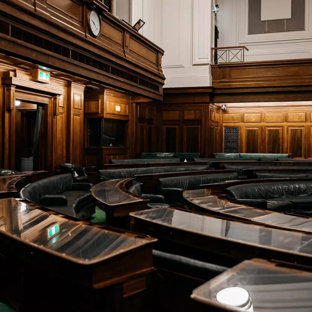 A row of desks in a U shape with green leather.