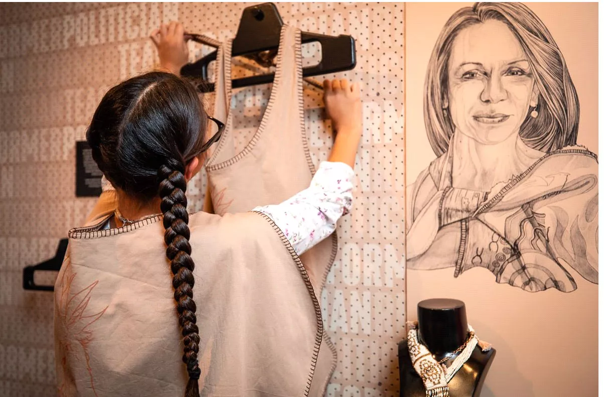 An older girl hanging a garment onto a hanger An older girl hanging a garment onto a hanger