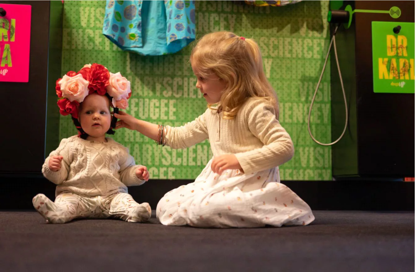 Two young children, one wearing a flower headband Two young children, one wearing a flower headband