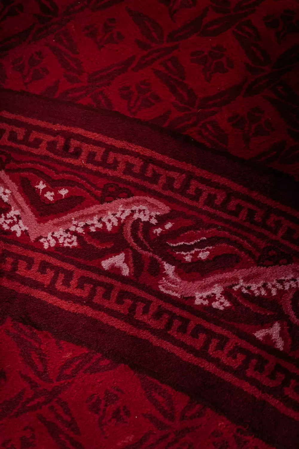 A close up of red carpet with an ornate pattern. A close up of red carpet with an ornate pattern.